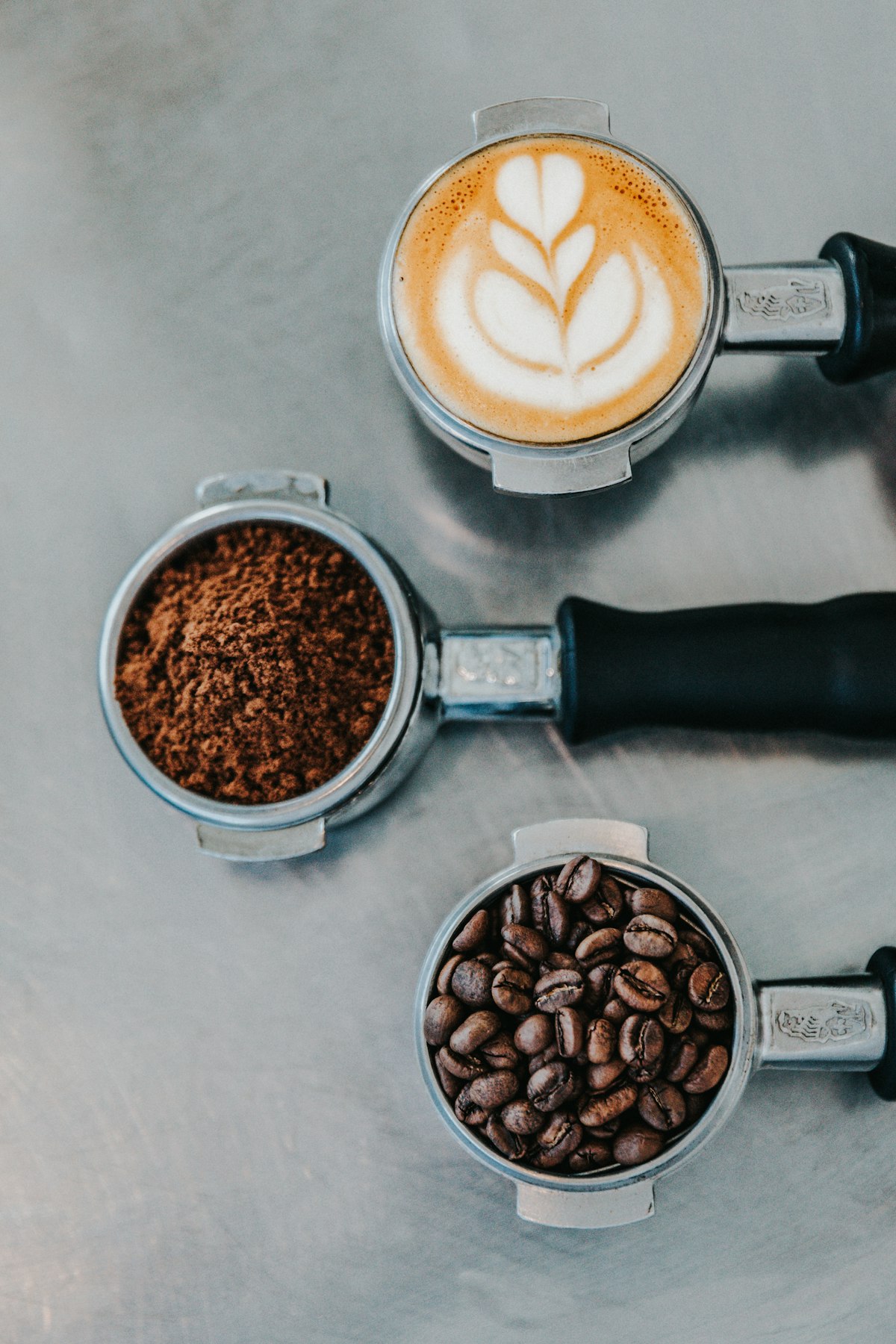 Espresso grounds, beans and a flat white on the bench
